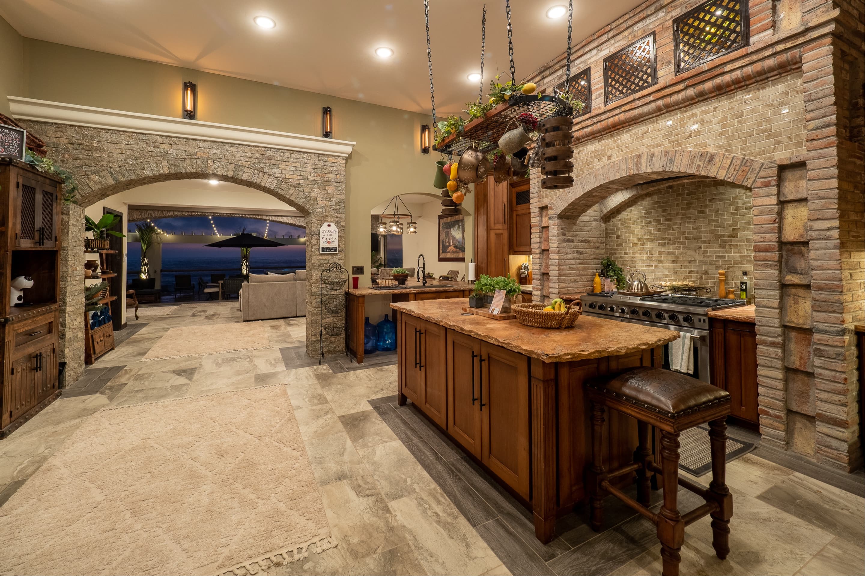 Chef's kitchen with brick archways opening toward the ocean